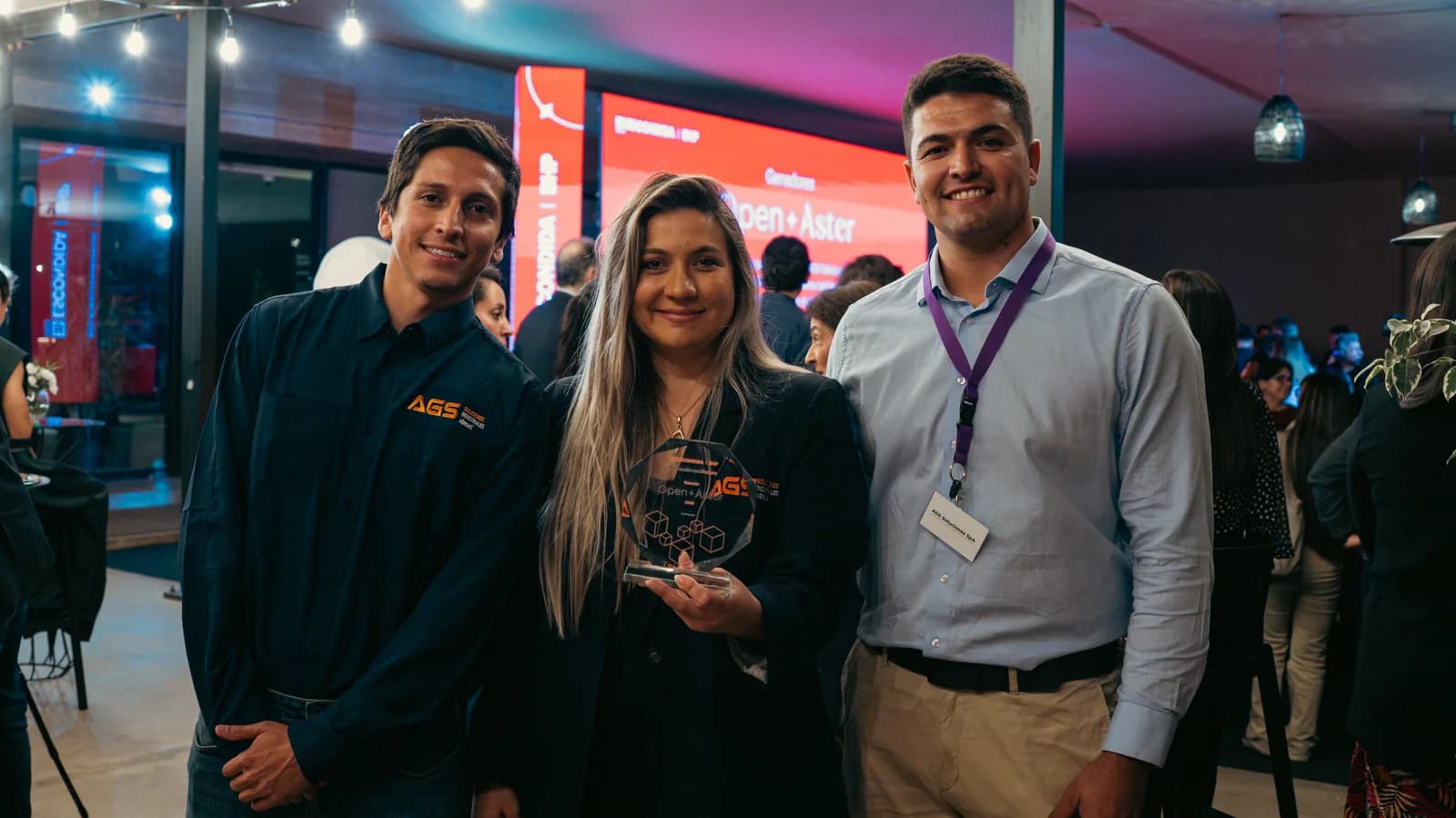 Three members of the AGS Soluciones team holding the Open Aster award from Escondida, BHP, at the awards ceremony
