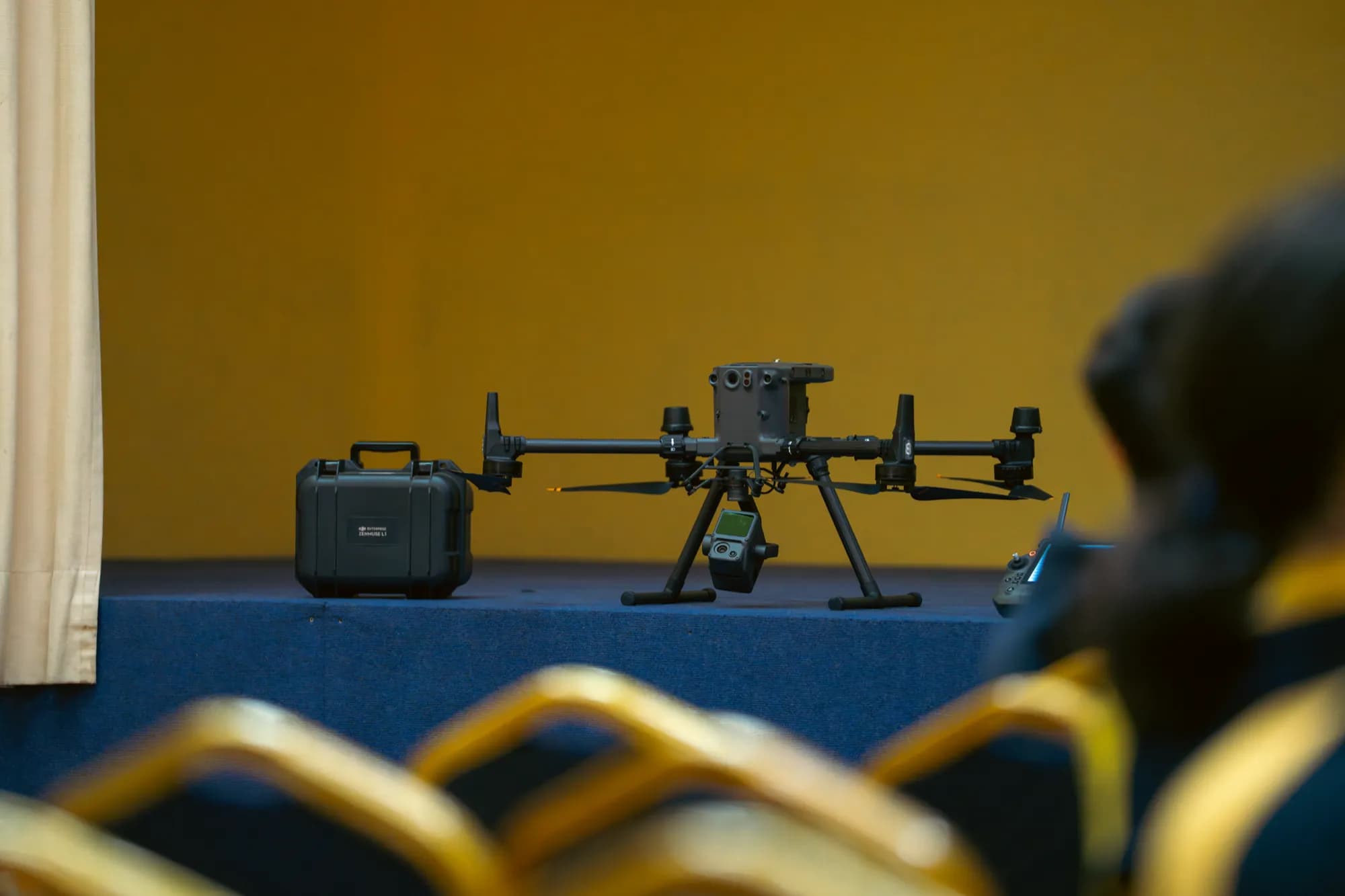 El dron industrial de AGS y su maleta de transporte sobre el escenario del auditorio